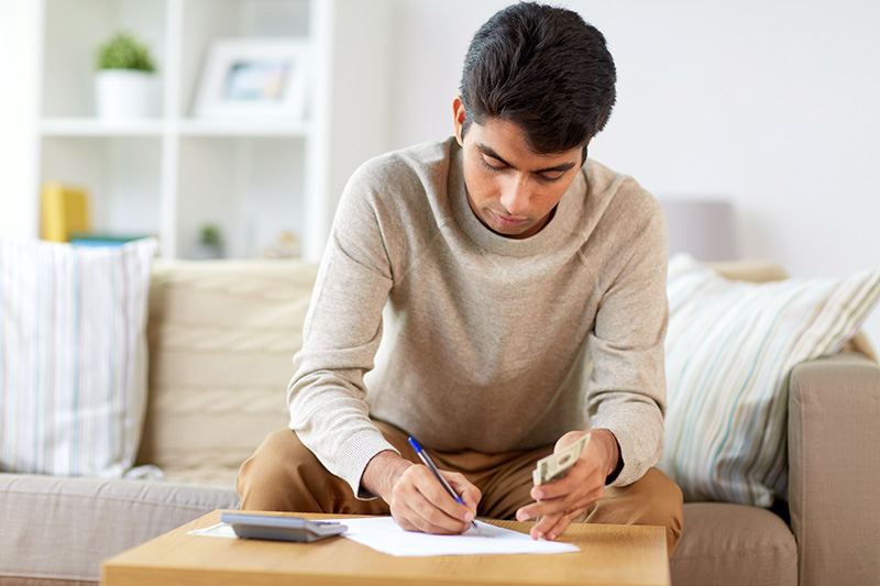 Man with calculator filling papers